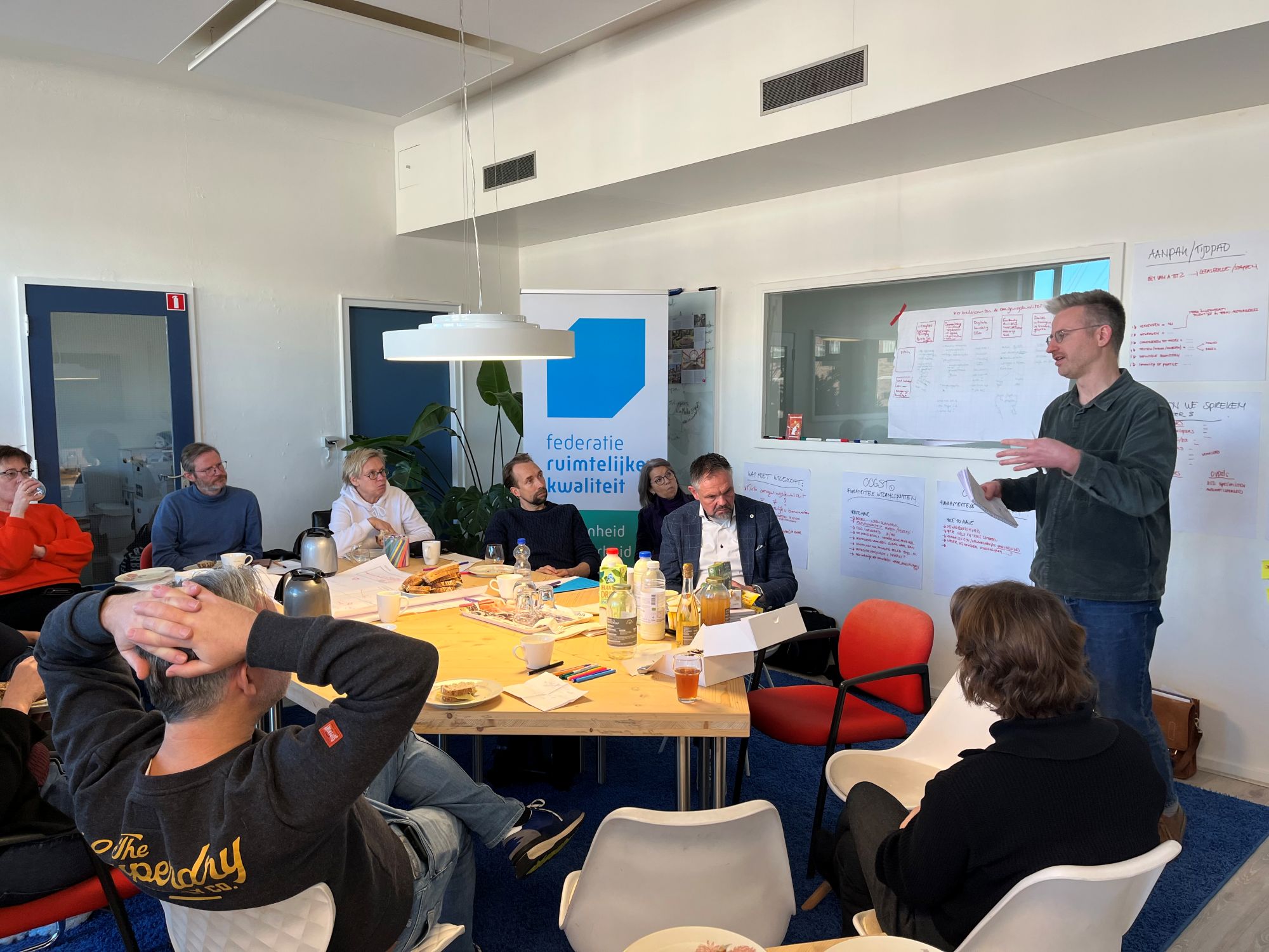 Groep mensen van de Federatie Ruimtelijke kwaliteit overlegt met elkaar aan tafel over Bouwstenen omgevingskwaliteit